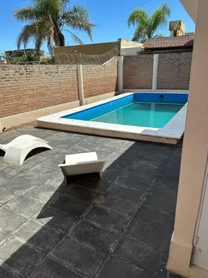a swimming pool in a yard next to a building at Casa Villa CARLOS PAZ CERCA DE COSTANERA in Villa Carlos Paz