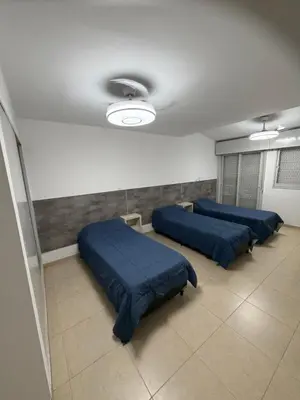 three beds in a room with blue sheets at Casa Villa CARLOS PAZ CERCA DE COSTANERA in Villa Carlos Paz