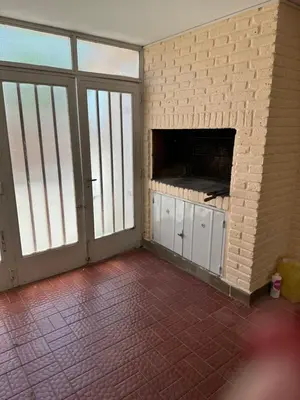an empty room with a brick wall with a fireplace at Casa Villa CARLOS PAZ CERCA DE COSTANERA in Villa Carlos Paz