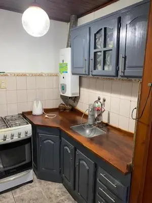 a kitchen with blue cabinets and a sink and a stove at Gratitud! in Almafuerte