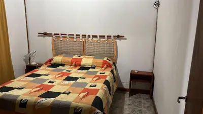 a bedroom with a bed with a colorful quilt at Gratitud! in Almafuerte