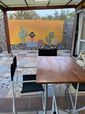 a table and chairs in a patio with a painting at Gratitud! in Almafuerte