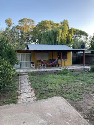 a yellow house with a hammock in front of it at Gratitud! in Almafuerte