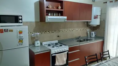 a kitchen with a white refrigerator and a stove top oven at La casa de Mayú in San Antonio de Arredondo