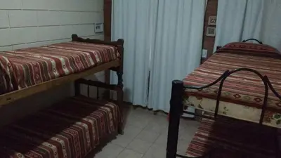 a room with two beds and a bench in it at La casa de Mayú in San Antonio de Arredondo