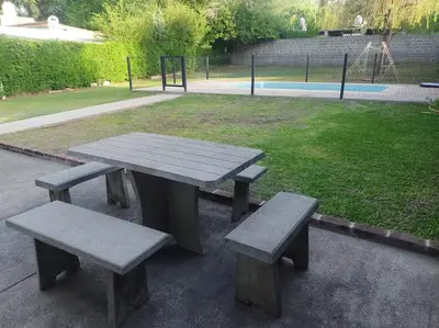 a picnic table and benches in a park at La casa de Mayú in San Antonio de Arredondo