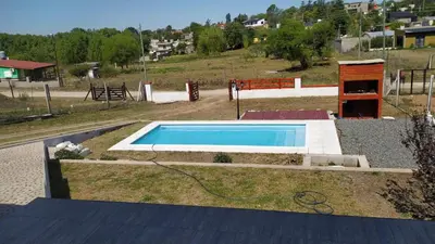 a swimming pool in the middle of a yard at La Estancita de Tanti con pileta in Tanti