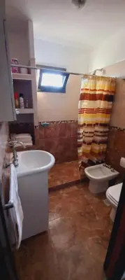 a bathroom with a sink and a toilet and a window at La Estancita de Tanti con pileta in Tanti