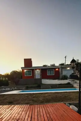 a house with a swimming pool in front of it at La Estancita de Tanti con pileta in Tanti