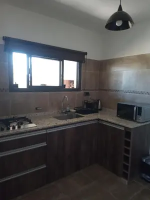 a kitchen with a sink and a microwave at Casa Moderna in Mina Clavero