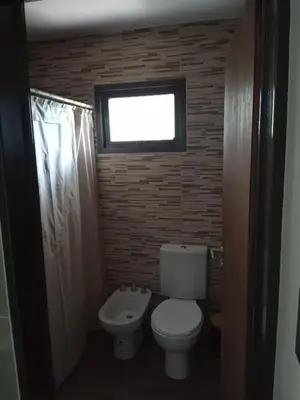 a small bathroom with a toilet and a window at Casa Moderna in Mina Clavero
