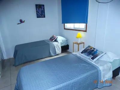 two beds in a room with blue walls at Cabaña La Chicha in Villa Anizacate
