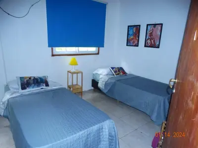 a bedroom with two beds and a blue wall at Cabaña La Chicha in Villa Anizacate
