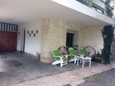 a group of green chairs and a table on a patio at Departamento Pama in Santa Rosa de Calamuchita