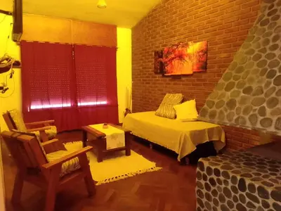 a bedroom with a bed and a brick wall at La Casa de la Parra in Villa Carlos Paz
