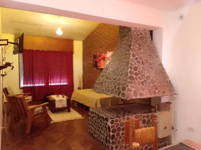 a living room with a fireplace in a bedroom at La Casa de la Parra in Villa Carlos Paz
