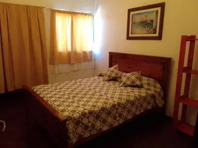 a bedroom with a bed in a room with a window at La Casa de la Parra in Villa Carlos Paz