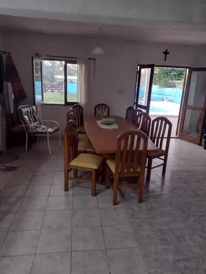 a dining room with a wooden table and chairs at El Abuelo in Santa Rosa de Calamuchita