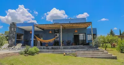 a blue house with a porch and stairs at Casa Relax Potrero de Garay in Potrero de Garay