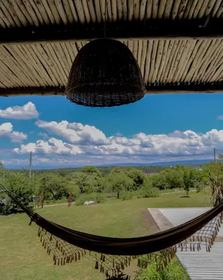 a hammock hanging from a roof with a view of a field at Casa Relax Potrero de Garay in Potrero de Garay