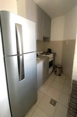 a stainless steel refrigerator in a kitchen with white cabinets at Espejito espejito in Cordoba