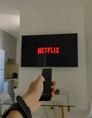 a person holding a remote control in front of a television at Espejito espejito in Cordoba