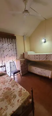 a bedroom with two beds and a ceiling fan at HERMINIA in Villa Carlos Paz
