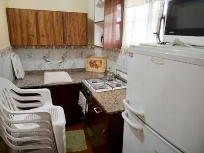 a small kitchen with a stove and a refrigerator at HERMINIA in Villa Carlos Paz