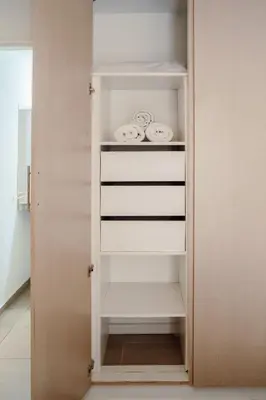 a closet with white shelves in a room at Departamento bien ubicado y cómodo by lofty in Cordoba