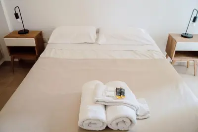 a white bed with towels on it at Departamento bien ubicado y cómodo by lofty in Cordoba