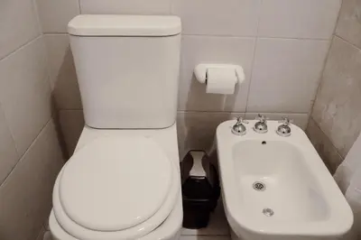 a bathroom with a white toilet and a sink at Departamento bien ubicado y cómodo by lofty in Cordoba
