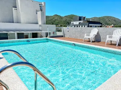 a swimming pool on the roof of a building at Berenice III Apartamentos in Villa Carlos Paz
