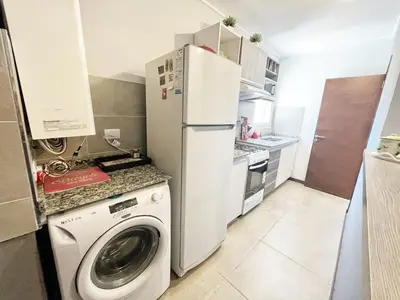 a kitchen with a washing machine and a refrigerator at Berenice III Apartamentos in Villa Carlos Paz