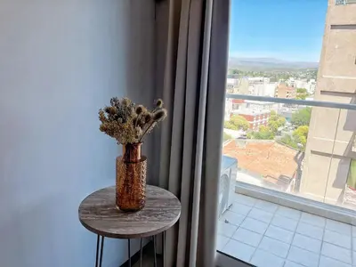 a vase sitting on a table in front of a window at Berenice III Apartamentos in Villa Carlos Paz