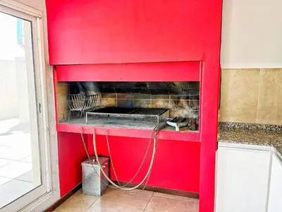 a red wall with a fireplace in a room at Berenice III Apartamentos in Villa Carlos Paz