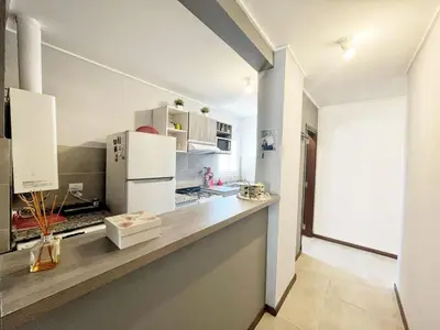 a kitchen with a counter with a refrigerator at Berenice III Apartamentos in Villa Carlos Paz