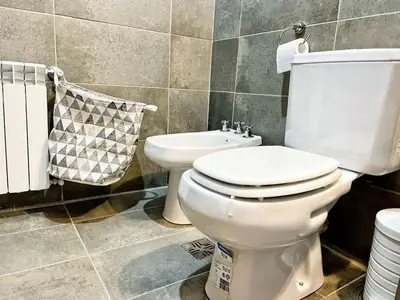 a bathroom with a white toilet and a sink at Berenice III Apartamentos in Villa Carlos Paz