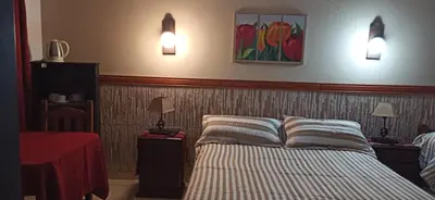 a bedroom with a bed and two lights on the wall at ENTRESIERRAS Y RIO in Santa Rosa de Calamuchita