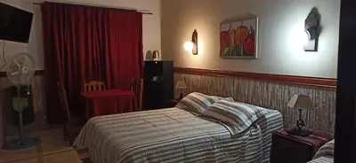 a bedroom with a bed and a red curtain at ENTRESIERRAS Y RIO in Santa Rosa de Calamuchita