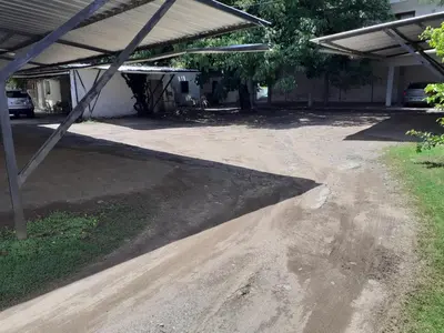 a dirt road in a parking lot next to a building at ENTRESIERRAS Y RIO in Santa Rosa de Calamuchita