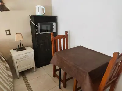 a dining room with a table and a tv at ENTRESIERRAS Y RIO in Santa Rosa de Calamuchita