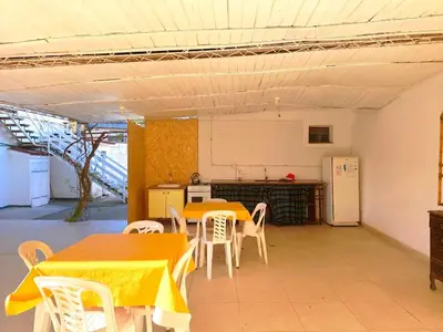 a kitchen with two tables and chairs and a refrigerator at ENTRESIERRAS Y RIO in Santa Rosa de Calamuchita