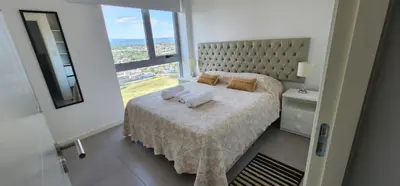 a bedroom with a bed and a large window at Gama Top con cochera in Cordoba