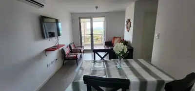 a living room with a table with a vase of flowers on it at Gama Top con cochera in Cordoba