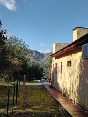 a side view of a building with mountains in the background at Casa Villa General Belgrano in Villa Ciudad Parque