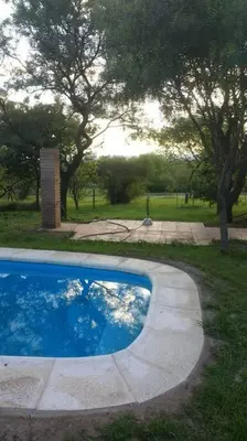 a swimming pool in the middle of a park at Casa Villa General Belgrano in Villa Ciudad Parque