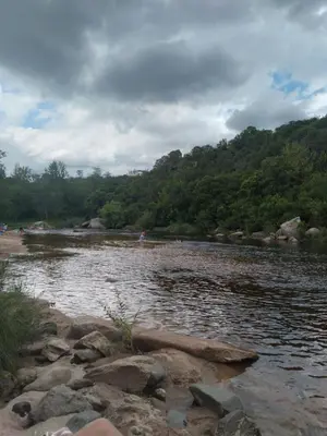 a body of water with people on the shore at Casa de montaña in Bialet Massé