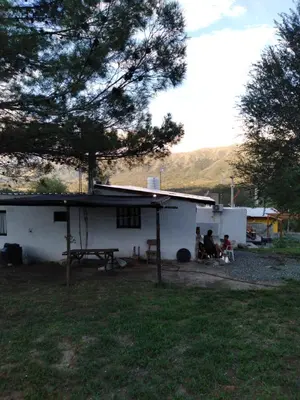 a group of people sitting outside of a white house at Casa de montaña in Bialet Massé