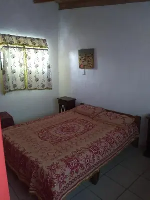 a bedroom with a bed with a red blanket on it at Casa de montaña in Bialet Massé