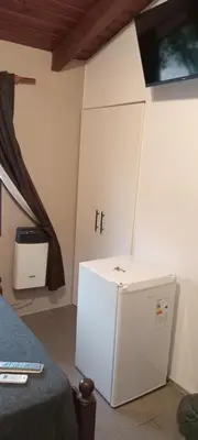a room with a white refrigerator in a room at QUIRUS DORMIS in Villa Carlos Paz